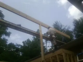 Carpenter setting a ridge beam over a new addition frame — Ice Dam Removal by Roofing Brothers in Lapel
