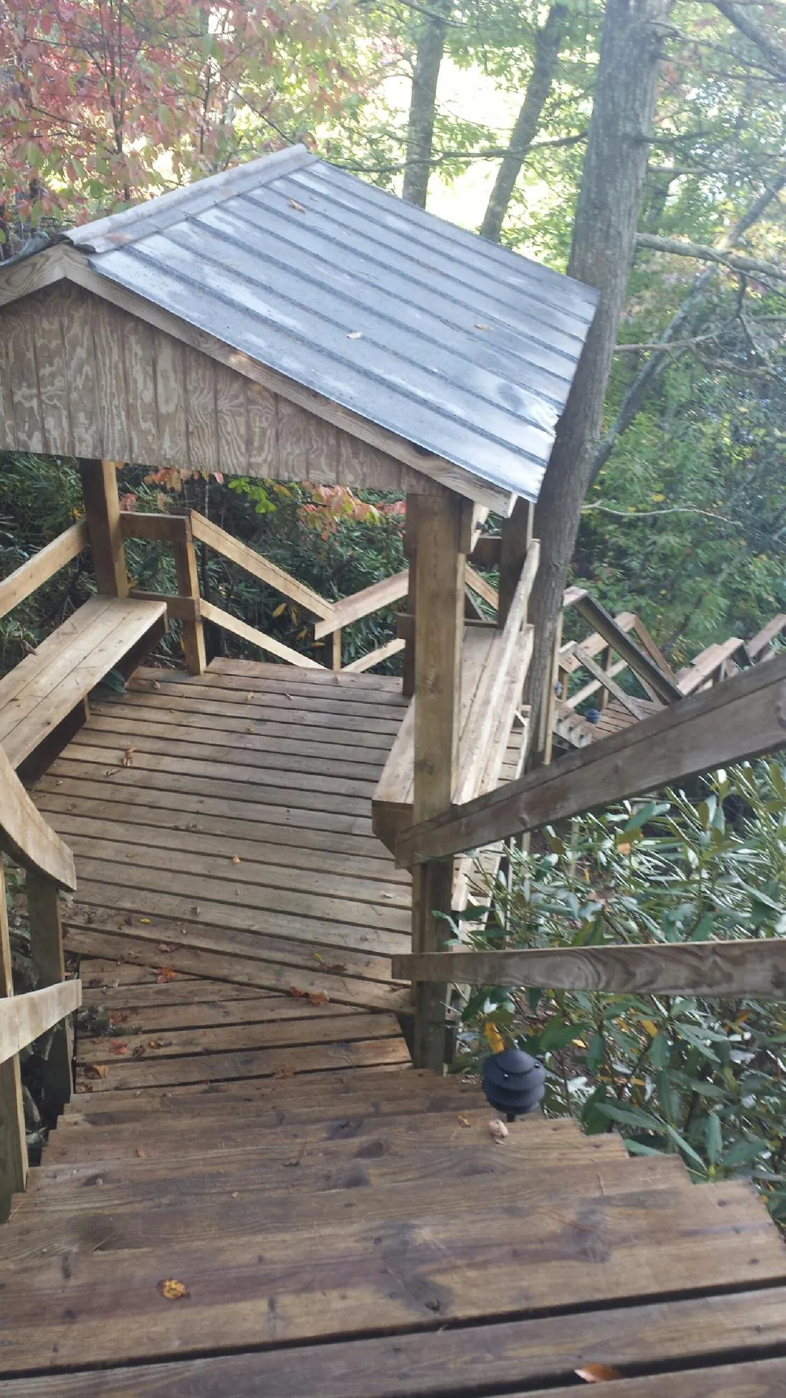 Metal roofed shelter over wooden steps on a wooded walkway — Skylight Repair & Installation work by our crew in Lapel