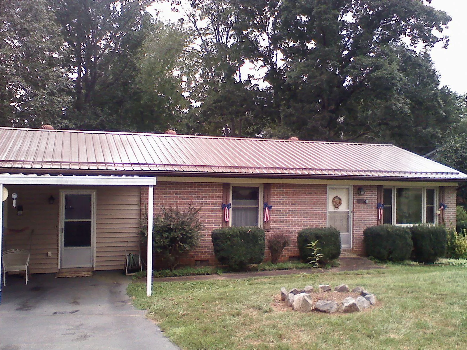 Bronze metal roof and carport on a brick ranch home — Roof Repair work by our crew in Lapel